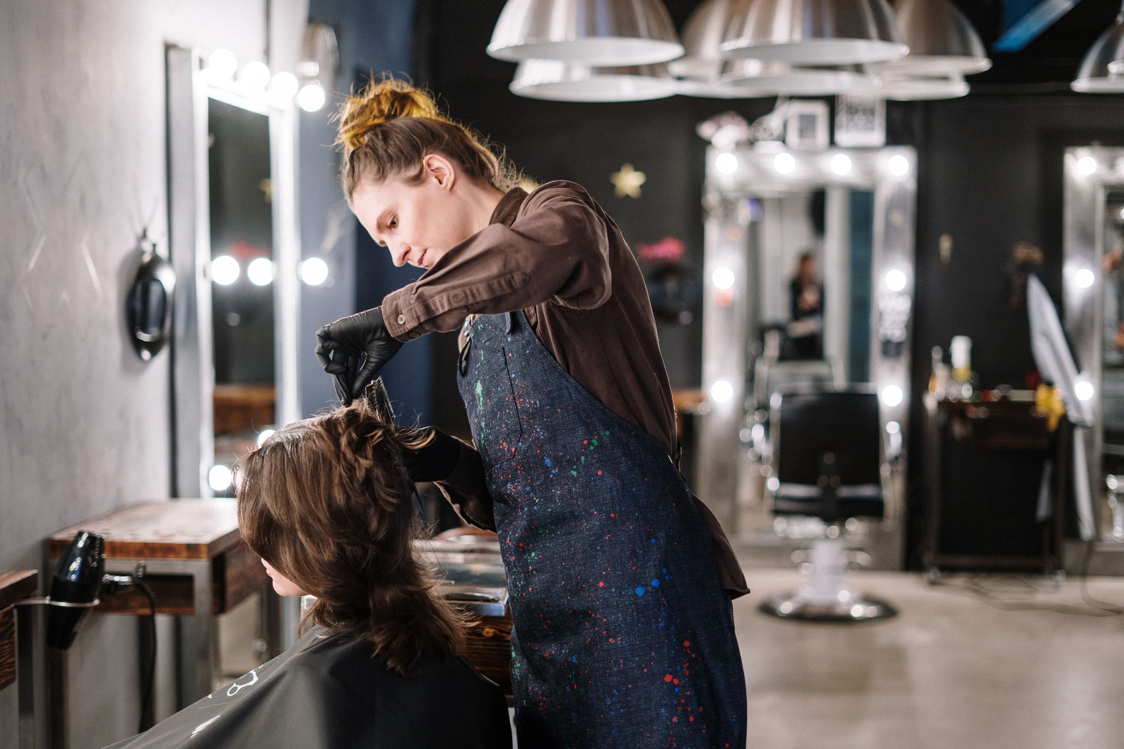 Professional hairdresser styling client at Revolet Unisex Salon